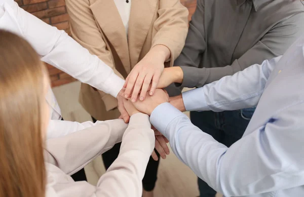 Groupe de personnes tenant leurs mains ensemble à l'intérieur, gros plan — Photo