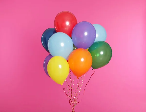 Manojo de globos brillantes sobre fondo de color — Foto de Stock
