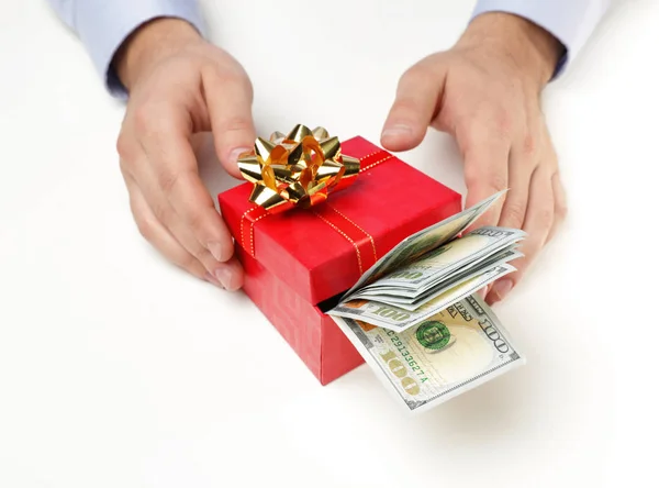 Hombre sosteniendo caja de regalo con billetes de dólar sobre fondo blanco, primer plano — Foto de Stock
