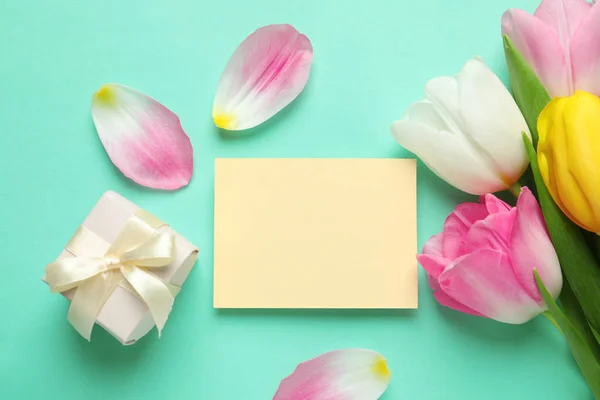 Composición plana de los tulipanes y la tarjeta en blanco sobre el fondo de color, espacio para el texto. Día Internacional de la Mujer —  Fotos de Stock