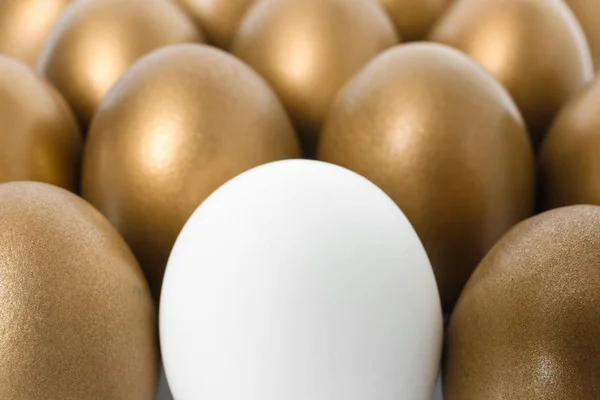 Χρυσά αυγά με διαφορετικές ως φόντο, κοντινό πλάνο — Φωτογραφία Αρχείου