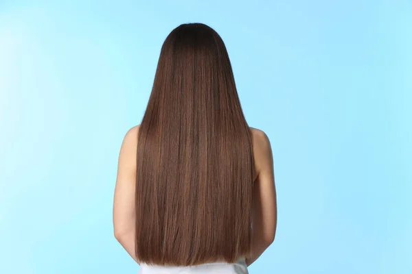 Kvinna med långt brunt hår på färgbakgrund — Stockfoto