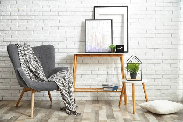 Elegante salón interior con cómodo sillón cerca de la pared de ladrillo —  Fotos de Stock