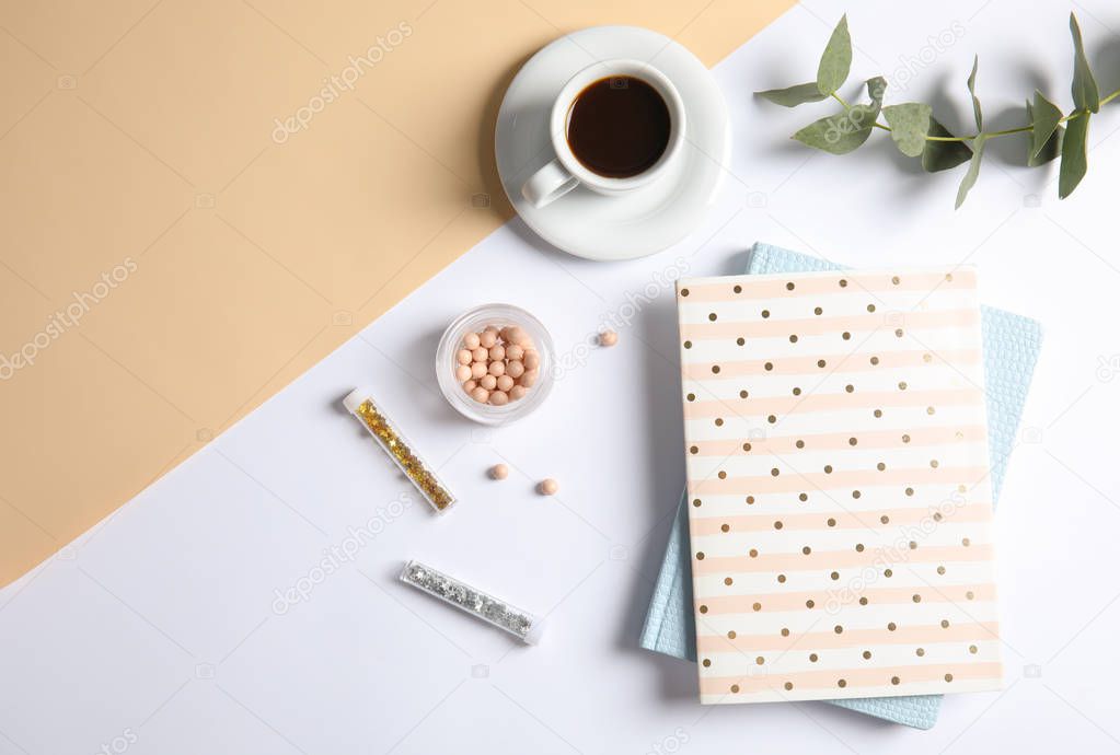 Flat lay composition with cup of coffee and notebooks on color background, space for text. Blogger's workplace