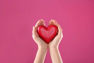 Dekoratif kalp renk arka plan, closeup üzerinde elinde tutan kadın