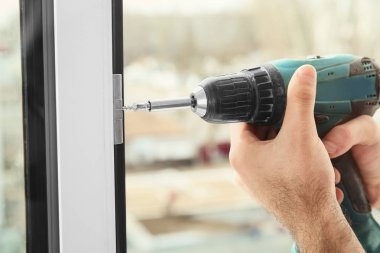 Süre installing pencere kapalı, closeup matkap kullanarak inşaat işçisi