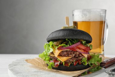 Siyah hamburger ve bira tablo üzerinde kurulu. Metin için yer