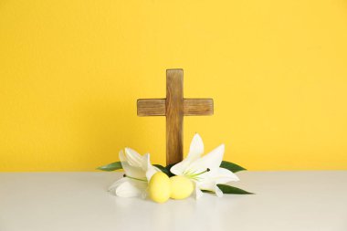 Tahta haç, Paskalya yumurtaları ve renk arka plan karşı masada lilyum çiçeği