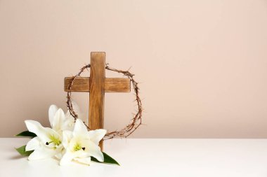 Çapraz, taç dikenler ve çiçek lilyum renk arka plan, metin için yer karşı masada ahşap