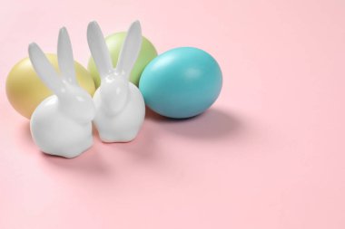 Seramik Easter bunnies ve renk arka plan, metin için yer üzerine boyalı yumurta