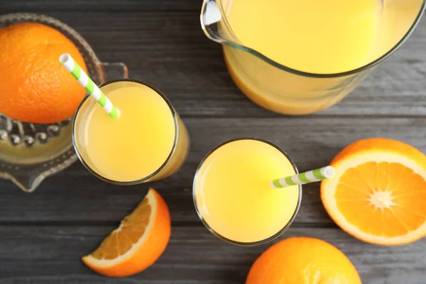 Komposisi rata dengan jus jeruk dan buah segar pada latar belakang kayu — Stok Foto