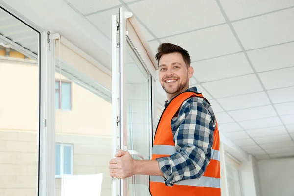 Travailleur de la construction installant fenêtre en plastique dans la maison — Photo