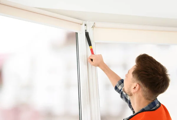 Bouwvakker, installeren van kunststof venster in huis — Stockfoto