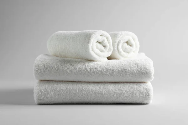 Stack of fresh towels on light background — Stock Photo, Image