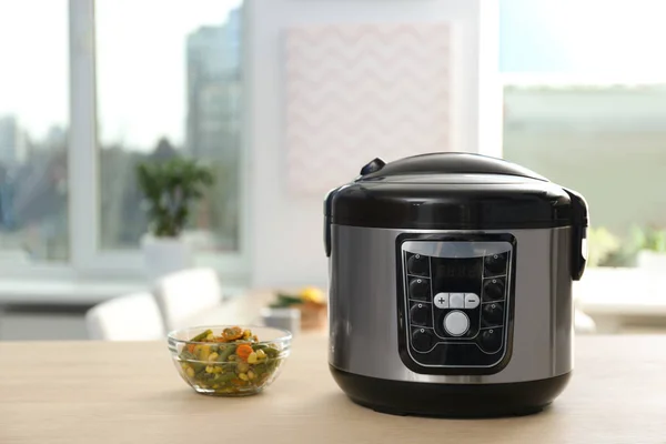 Modern multi cooker and ingredients on table in kitchen. Space for text — Stock Photo, Image