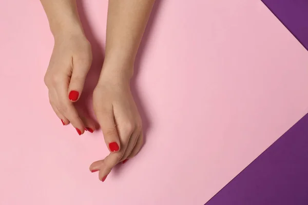 Mujer mostrando manicura roja sobre fondo de color, vista superior con espacio para texto. Tendencias de esmalte de uñas — Foto de Stock