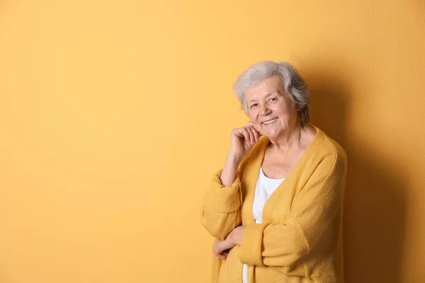 Portrait of grandmother in stylish clothes on color background, space for text — Stock Photo, Image