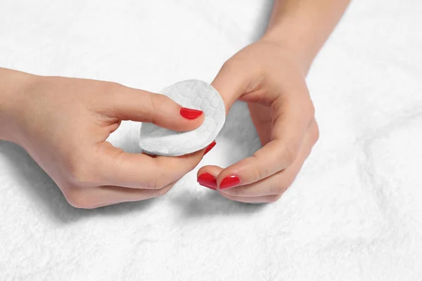 Mujer quitando esmalte de uñas en tela blanca, primer plano — Foto de Stock