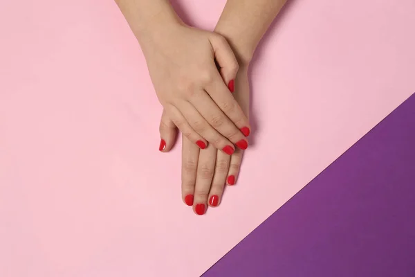 Mujer mostrando manicura roja sobre fondo de color, vista superior. Tendencias de esmalte de uñas — Foto de Stock