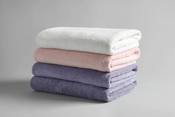 Stack of fresh fluffy towels on grey background — Stock Photo, Image