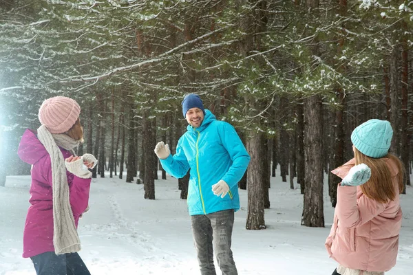 Счастливая семья играет в снежки в зимнем лесу — стоковое фото