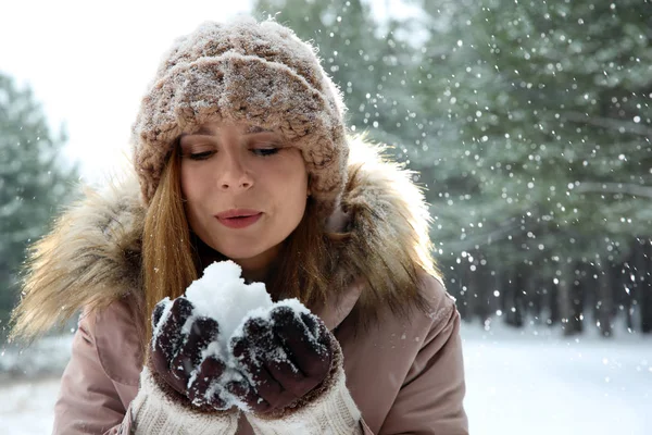 Vacker kvinna blåser snö i vinter skog. Utrymme för text — Stockfoto