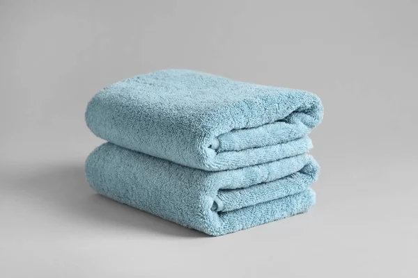 Stack of fresh fluffy towels on grey background — Stock Photo, Image