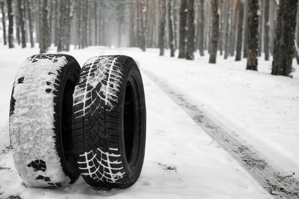 Új téli gumik a friss hó, erdő közelében. Hely a szöveg — Stock Fotó