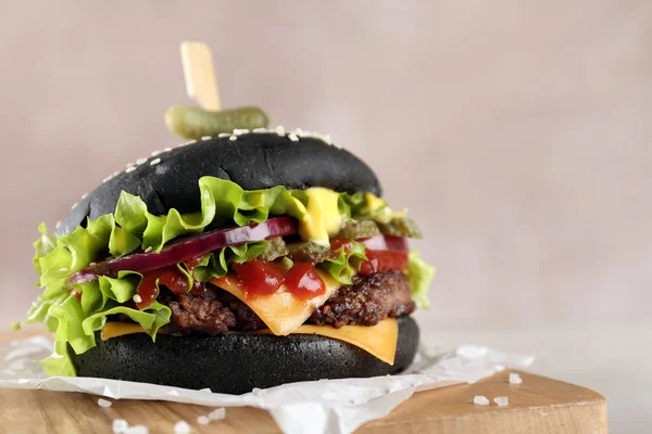 Bord met zwarte Hamburger op tafel, close-up. Ruimte voor tekst — Stockfoto