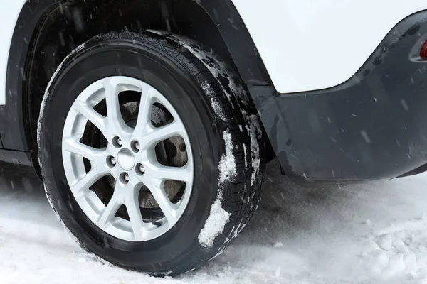 Modernes Auto auf schneebedeckter Winterstraße, Nahaufnahme — Stockfoto