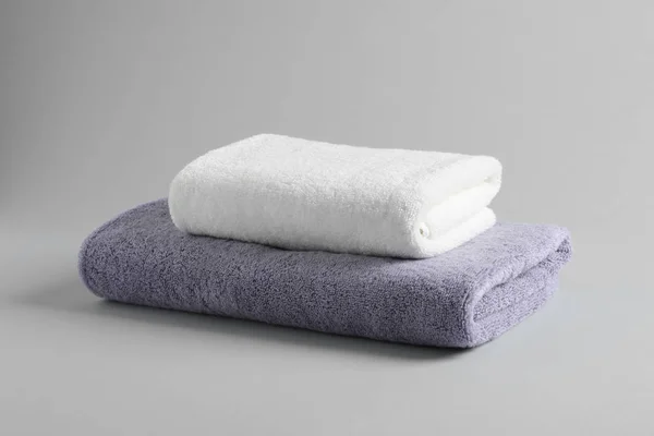 Stack of fresh fluffy towels on grey background — Stock Photo, Image