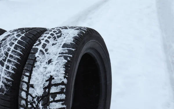 New winter tires on fresh snow, closeup. Space for text