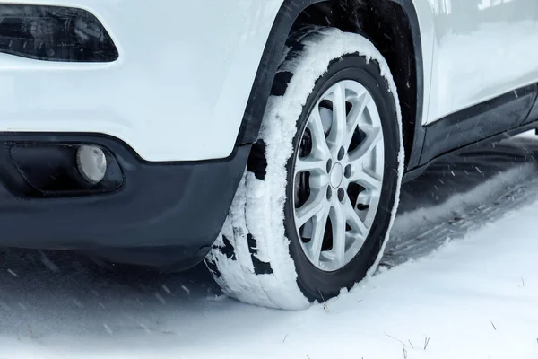 Σύγχρονο αυτοκίνητο σε χιονισμένο δρόμο, closeup προβολή. Χειμερινή περίοδος — Φωτογραφία Αρχείου
