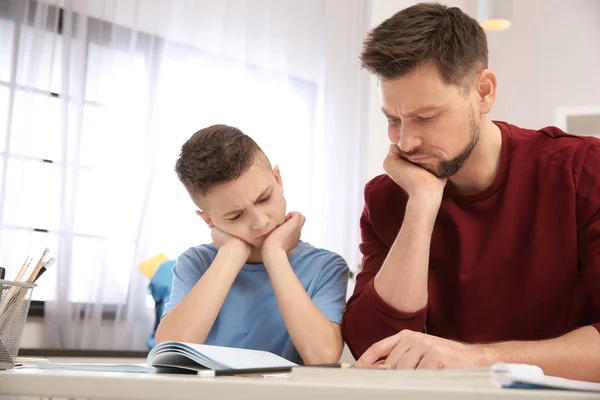 Papá ayudando a su hijo con la tarea difícil asignación en la habitación — Foto de Stock