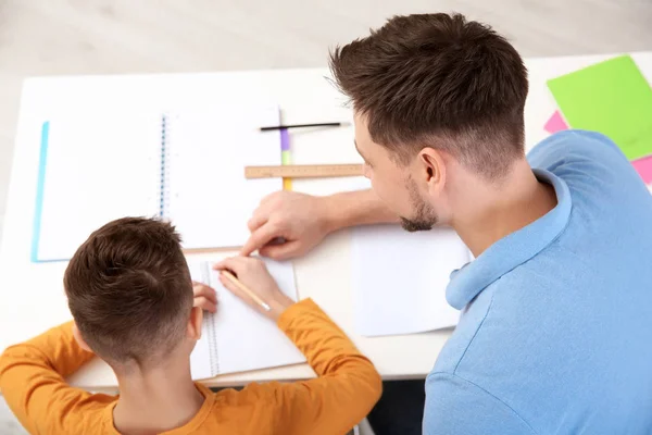 Papá ayudando a su hijo con la tarea en la habitación, por encima de vista — Foto de Stock