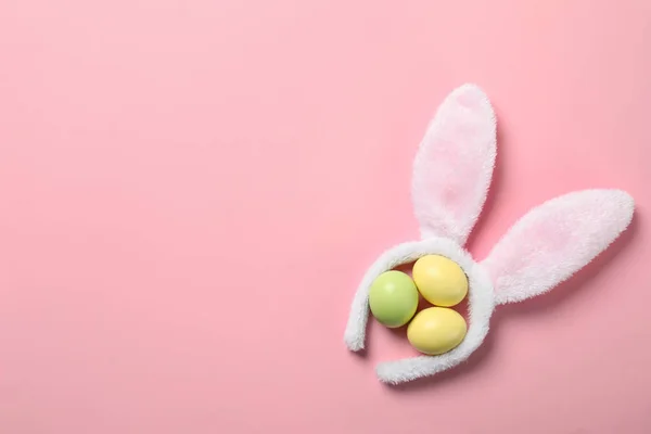 Vicces fejpánt-val húsvéti nyuszi füle és festett tojásokat színes háttéren, lapos feküdt. Hely a szöveg — Stock Fotó