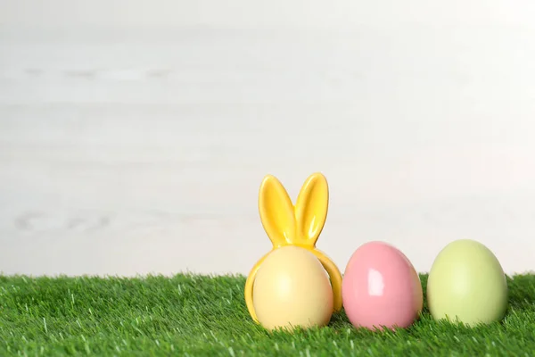 可爱的染色鸡蛋与装饰复活节兔子耳朵在绿草, 文本空间 — 图库照片