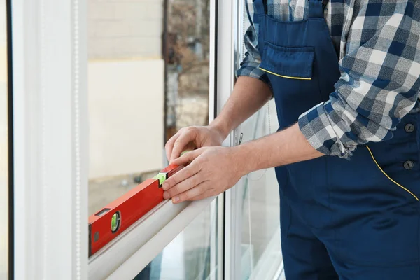 Construction worker using bubble level while installing window indoors, closeup — Stock Image Construction worker using bubble level while installing window indoors, closeup Royalty Free Stock Images