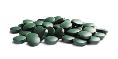 Spirulina tablet beyaz zemin üzerine yığını