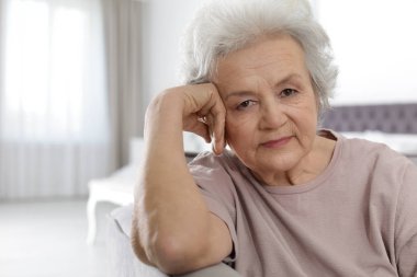 Oturma odasında olgun bir kadının portresi.