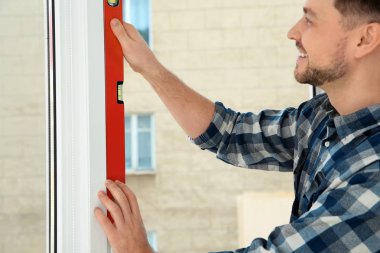 Süre installing pencere kapalı, closeup kabarcık düzeyi kullanarak inşaat işçisi