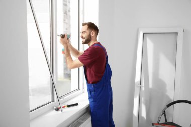 Süre installing pencere kapalı matkap kullanarak inşaat işçisi