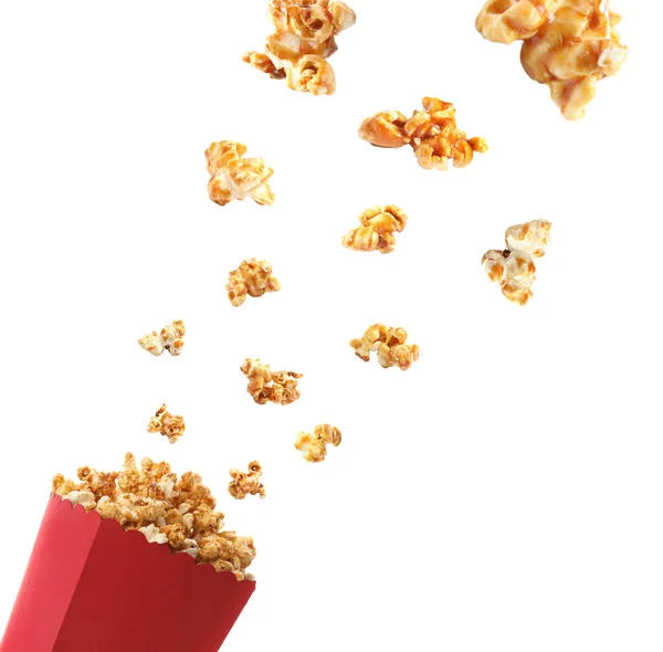 Köstliches Karamell-Popcorn fällt in Pappbecher auf weißem Hintergrund — Stockfoto