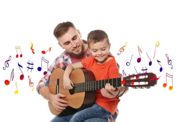 Padre enseñando a su pequeño hijo tocando la guitarra y volando notas musicales sobre fondo blanco — Foto de Stock