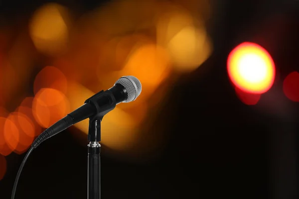 Modern microphone on stand against blurred background, space for text — Stock Photo, Image
