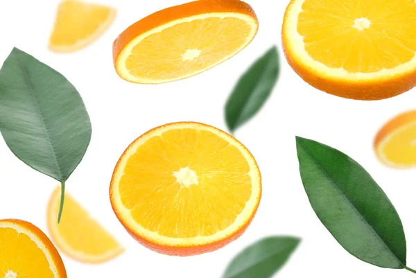 Voando suculentas fatias de laranja e folhas cítricas no fundo branco — Fotografia de Stock