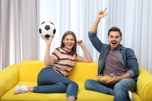Para oglądania meczu piłki nożnej na telewizor w salonie — Zdjęcie stockowe