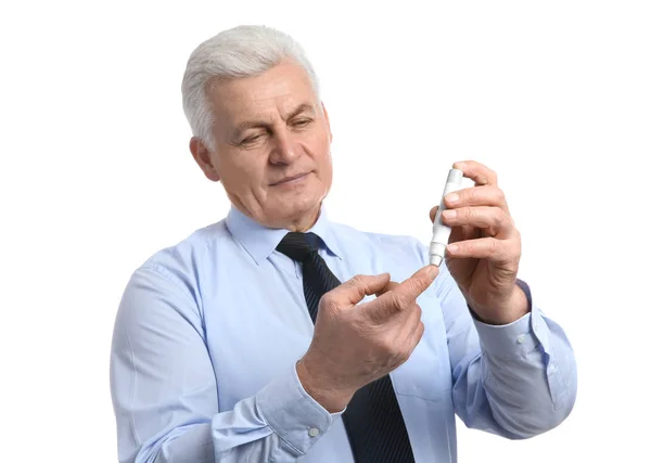 Hombre mayor usando lápiz de lanceta sobre fondo blanco. Control de la diabetes —  Fotos de Stock