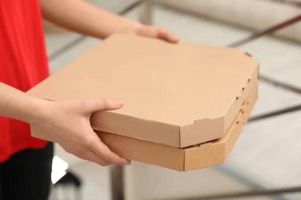 Жінка-кур'єр з коробками для піци в приміщенні, крупним планом. Служба доставки їжі — стокове фото