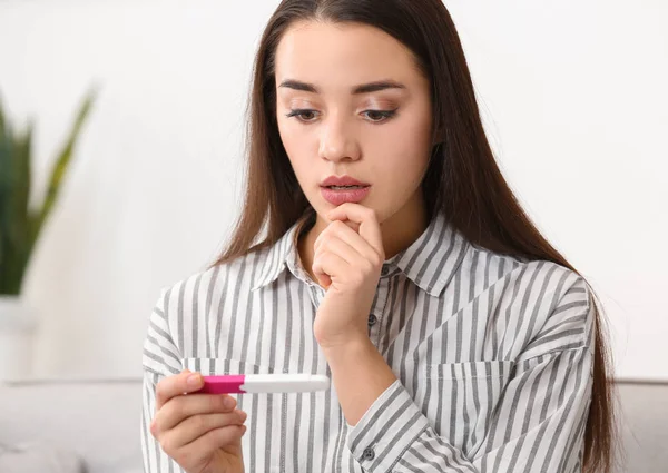 Молодая женщина с тестом на беременность дома. Гинекология и роды — стоковое фото